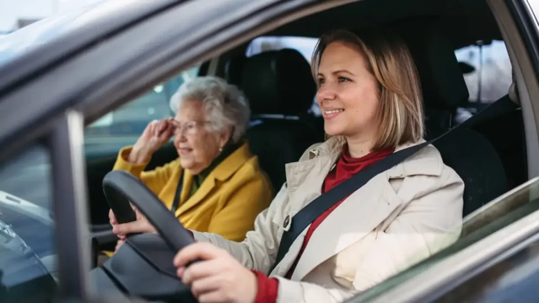 Woman drives an elderly lady in her car